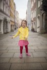 Germany, Bavaria, smiling little girl standing in an alley — Stock Photo