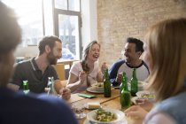 Amici felici mangiare insieme a casa — Foto stock