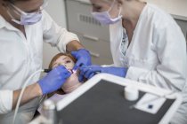 Dentista con assistente che esegue un controllo per il paziente — Foto stock
