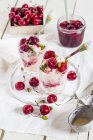 Glasses of vanilla icecream with amarena cherries and pistachios — Stock Photo
