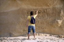 Homme sculptant quelque chose sur la paroi rocheuse — Photo de stock