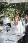 Frau lächelt Mann vor Restaurant an — Stockfoto