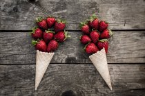 Cônes en forme de fraises et crème glacée — Photo de stock
