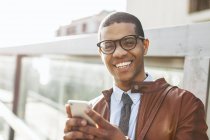 Homme d'affaires souriant avec smartphone — Photo de stock