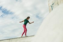 Mulher balanceamento na parede no skatepark — Fotografia de Stock