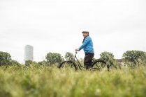 Senior man riding bicycle — Stock Photo