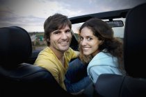 Пара сидящая в кабриолете на побережье — стоковое фото