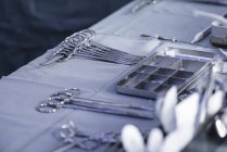 Instrumentos quirúrgicos dispuestos sobre tela blanca - foto de stock