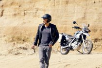 Uomo maturo con moto in pozzo di sabbia — Foto stock
