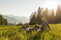 Австрия, Тироль, Таннхаймер Таль, молодая пара отдыхает на альпийском лугу — стоковое фото