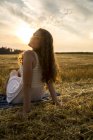 Жінка сидить на солому поля — стокове фото