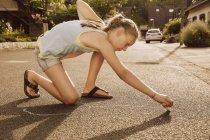 Ragazza che utilizza il gesso marciapiede nel suo quartiere — Foto stock