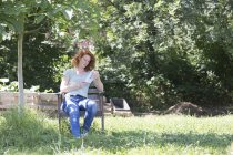 Young woman reading in garden — Stock Photo