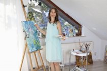Retrato de pintora feliz no trabalho em seu estúdio — Fotografia de Stock