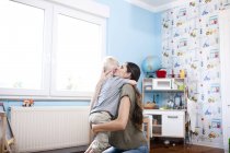 Мать и маленький сын вместе в детской комнате — стоковое фото