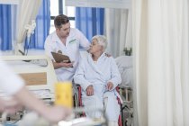 Nurse with elderly female patient in wheelchair — Stock Photo