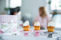 Drei Tassen Kuchen auf Blech, Menschen im Hintergrund zu Hause — Stockfoto