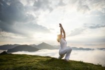 Austria.Kranzhorn, Mid donna adulta che pratica yoga in cima alla montagna — Foto stock
