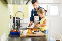 Father and daughter in kitchen preparing fruit cake — Stock Photo