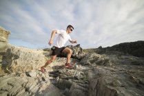 Spain, Valdovino, young man running on the rocks — Stock Photo