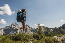 Austria, Tyrol, Tannheimer Tal, young woman hiking on mountain trail — Stock Photo