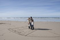 Сім'я гра tic tac toe на пляжі в красивою природою — стокове фото
