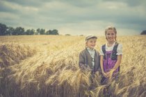 Due bambini in piedi in un campo di grano — Foto stock