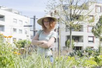 Giovane donna in piedi in un piccolo giardino in città, il concetto di giardinaggio urbano — Foto stock