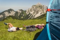 Österreich, Tirol, Tannheimer Tal, junges Paar ruht sich neben Zelt auf Alm aus — Stockfoto