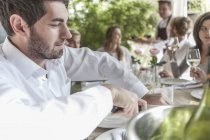 Friends having lunch together at restaurant, sitting outside — Stock Photo