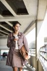 Молодая женщина использует смартфон на парковке — стоковое фото