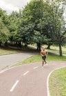Atlético jovem jogging no parque — Fotografia de Stock