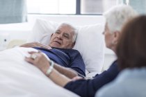 Famiglia in visita al paziente anziano in ospedale — Foto stock