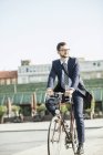 Joven hombre de negocios montar en bicicleta - foto de stock