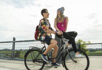 Jovem casal feliz juntos em uma bicicleta — Fotografia de Stock