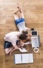 Two caucasian students on wooden floor learning — Stock Photo