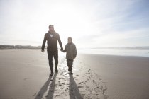 África do Sul, Witsand, pai e filho caminhando na praia no backlight — Fotografia de Stock