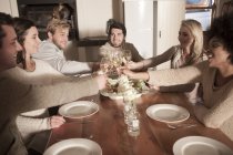 Amici clinking bicchieri di vino a tavola a cena cucina moderna — Foto stock