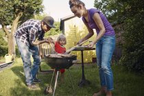 Happy family having a barbecue in garden — Stock Photo