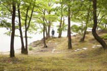 Uomo d'affari che cammina nella foresta con fogli di carta a terra — Foto stock