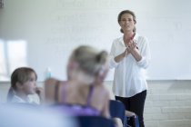 Insegnante in classe a parlare con le studentesse alla lavagna — Foto stock
