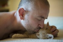 Uomo che bacia gattino, primo piano — Foto stock