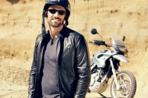 Uomo maturo con moto in pozzo di sabbia — Foto stock