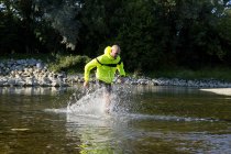 Мужчина в спортивной одежде бегает в воде — стоковое фото