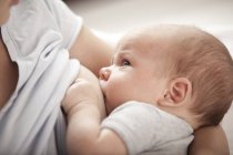 Giovane donna che allatta il suo bambino — Foto stock
