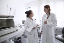 Tecnici di laboratorio con rivista in laboratorio — Foto stock