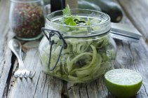 Einmachglas mit geschnittenen Zucchini mit Limette und Gewürzen — Stockfoto