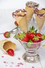 Vidrio con fresas, conos de helado con cobertura - foto de stock