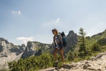 Austria, Tyrol, Tannheimer Tal, young woman hiking on mountain trail — Stock Photo