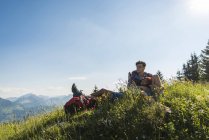 Австрия, Тироль, Таннхаймер Таль, молодая пара отдыхает на альпийском лугу — стоковое фото